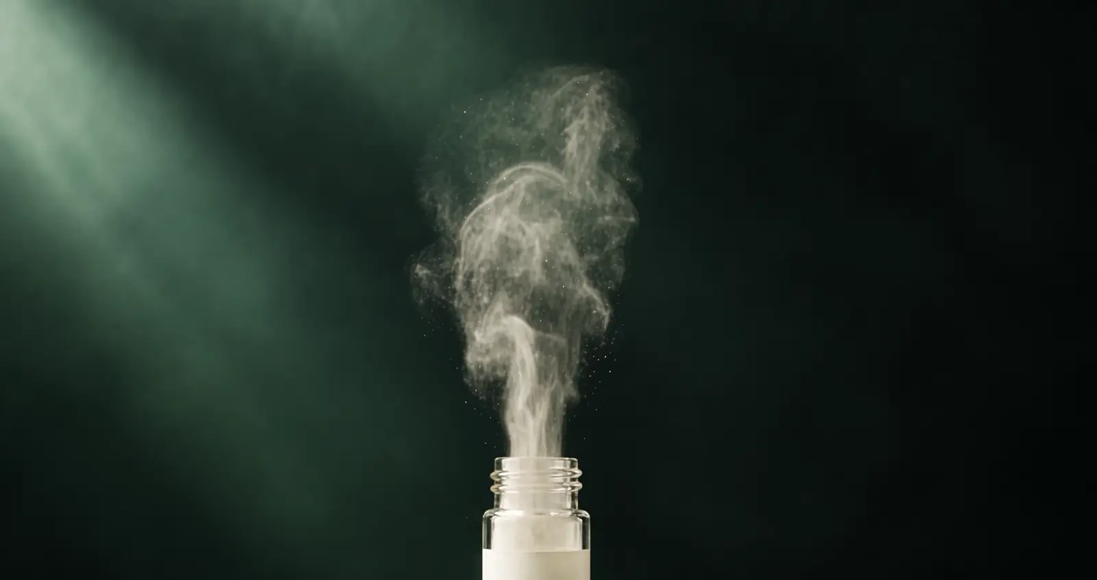 A fine plume of powder rising from an open CocaVida vial